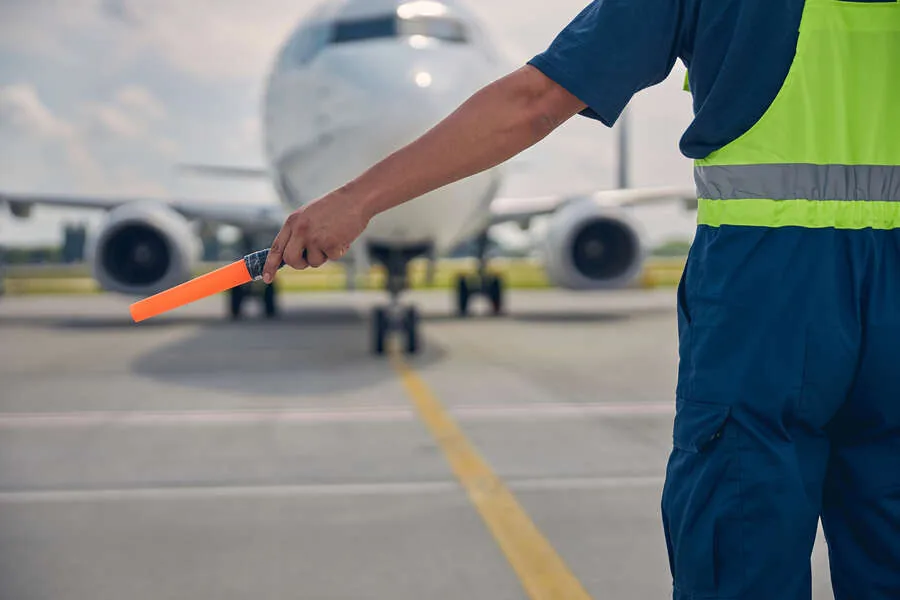 Ramp Agent weist ein Flugzeug auf dem Vorfeld ein